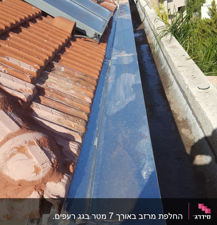 גג רעפים עם לוחות סולאריים ותעלת ניקוז מתכתית